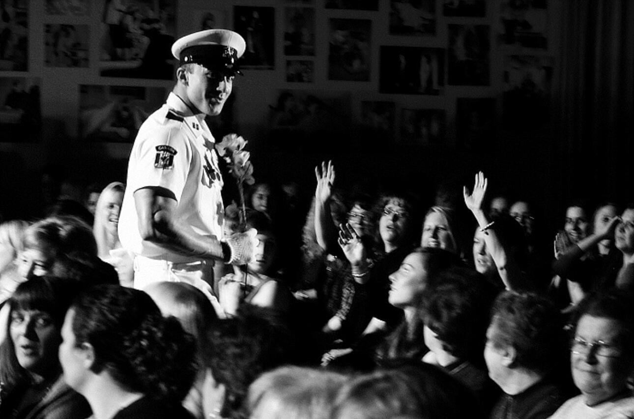 Tom Rooney professional picture performing in audience Black and white photo of headline Performer and author Thomas (Tom) Rooney in performing as a naval officer and surrounded by an audience of enthusiastic women