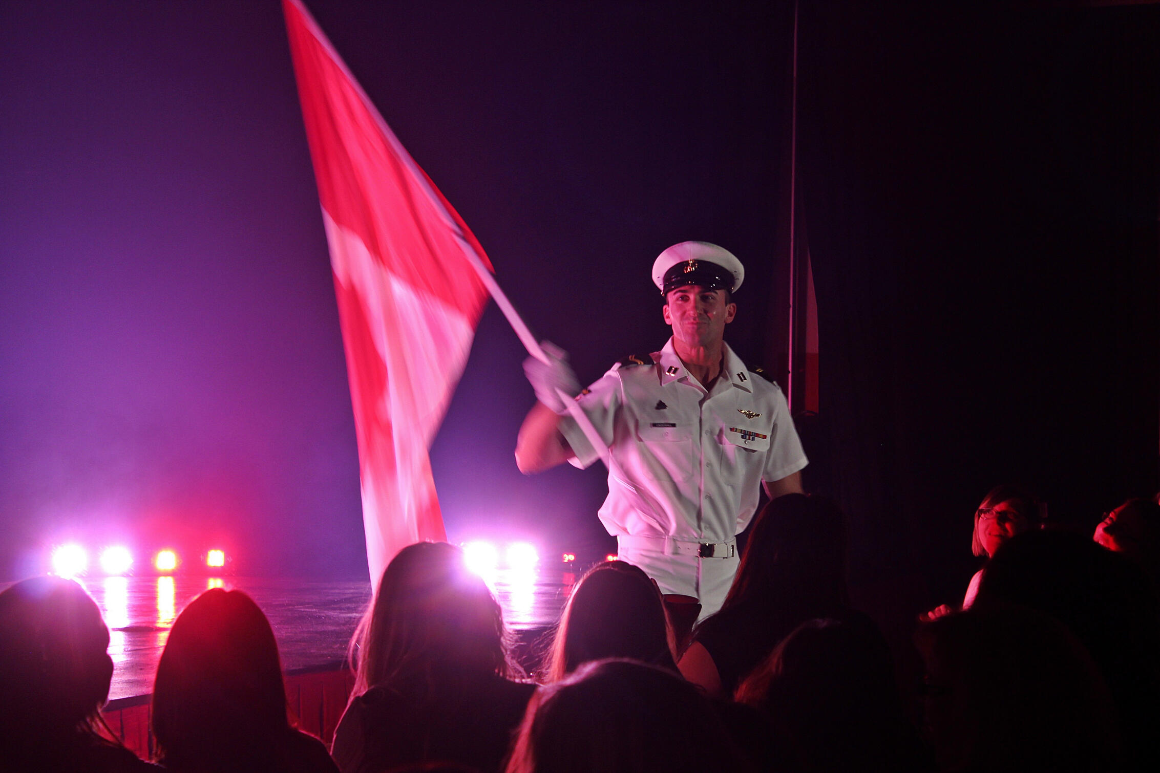 Thomas (Tom) Rooney Headline Performer live performance photo Performer and author Thomas (Tom) Rooney waving a Canadian flag on stage during a Canadian Storm live show