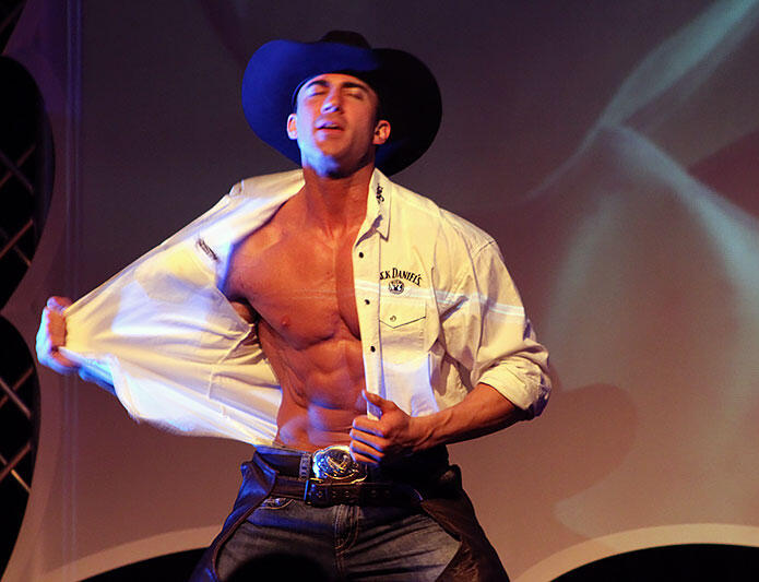 Canadian Storm - Tom Rooney on stage Headline performer Thomas (Tom) Rooney on stage with Canadian Storm Male Revue with shirt unbuttoned as a cowboy