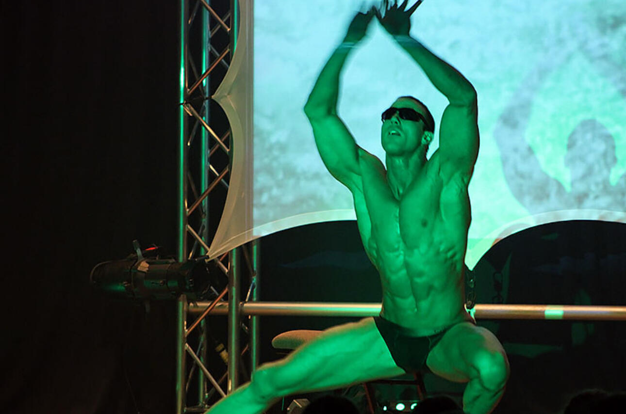 Canadian Storm - Tom Rooney live photo during Matrix Performance Performer Thomas (Tom) Rooney of Canadian Storm Male Revue on stage with arms raised performing his Matrix show as Neo